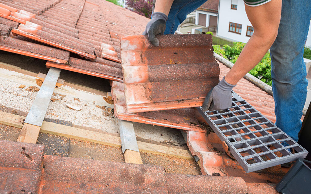 Esecuzione lavori di rifacimento tetto con posa delle tegole sulla copertura